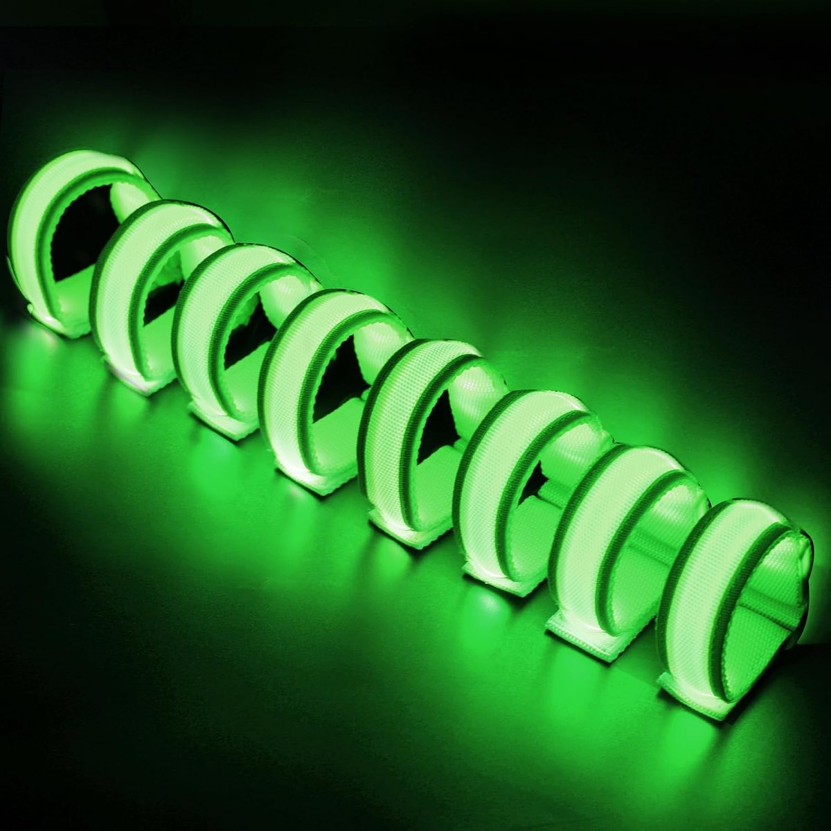 Eight FANL green LED glow bracelets glowing on a dark surface